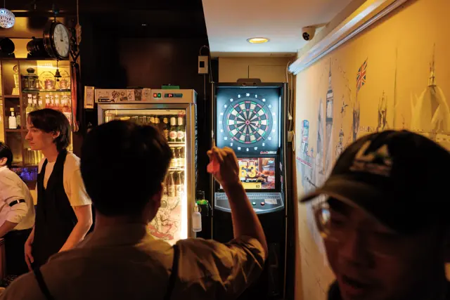 Guests near the electronic dartboard